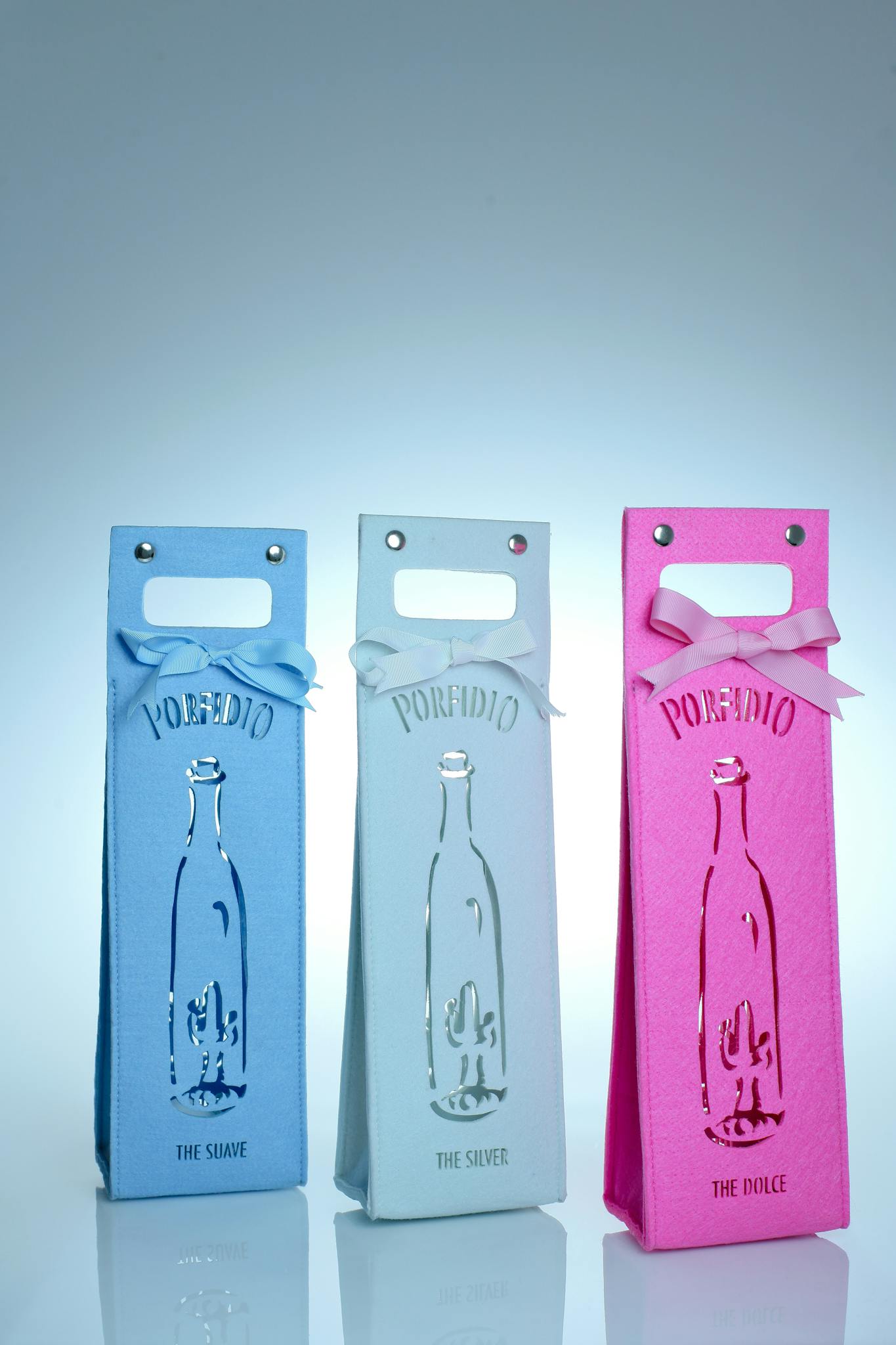 Stylish blue, white, and pink gift bags with ribbon accents on a white background.